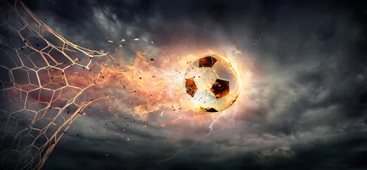 Afwasbaar behang Bestsellers Sport Doel - Vurige voetbal die door het net breekt met dramatische lucht