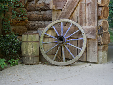 Old wooden wheel and two old wooden barrels