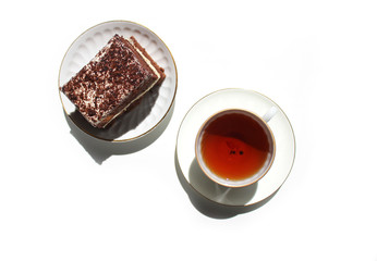 Homemade chocolate brownies with cup of tea on white background