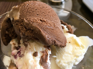chocolate and cream ice cream in a glass cup on the table