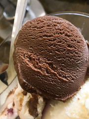 chocolate and cream ice cream in a glass cup on the table