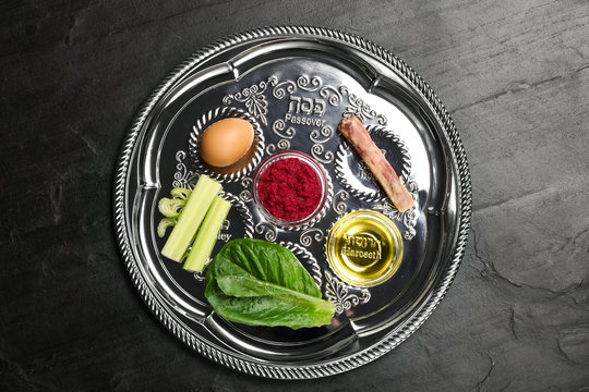 Passover Seder plate (keara) on black table, top view. Pesah celebration