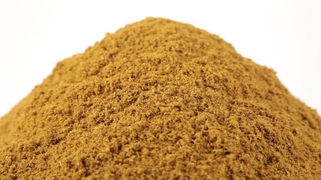 Curry grains of spin around themselves on white background