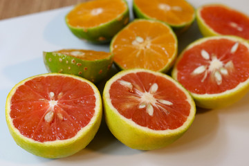 Beautiful lemons and grapefruits cut in half on a cutting board.
