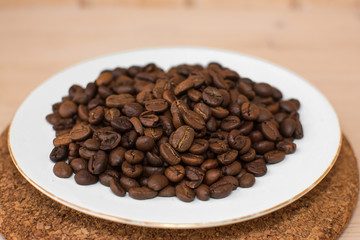 coffee beans on a white plate and cork stand background