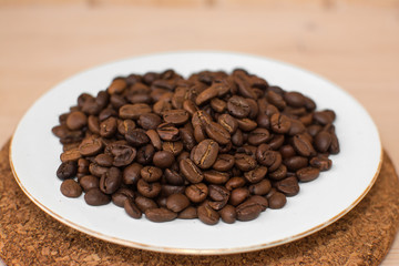 coffee beans on a white plate and cork stand background