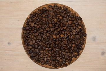brown coffee beans on a wooden background and cork stand