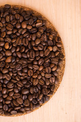 brown coffee beans on a wooden background and cork stand
