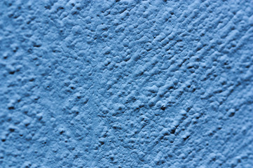 Blue wall with small lumps that make it rough