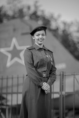 Retro style black and white photography. A young female pilot in uniform of Soviet Army pilots...