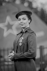 Retro style black and white photography. A young female pilot in uniform of Soviet Army pilots...