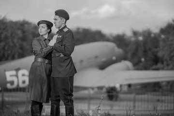 Retro style black and white photography. Young adult man and woman in the Military uniform of...