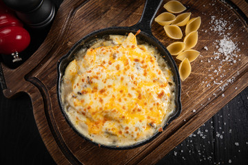 Pasta with cheese and chicken on a black background