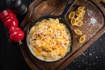 Pasta with cheese and chicken on a black background