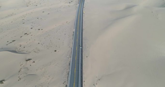 Revealing shot of cyclist riding through North Algodones dunes