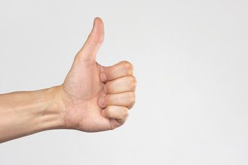Hand with raised thumb on a white background. Hand showing like. The concept of "all is well".