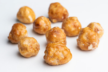 Roasted hazelnuts in caramel on a white background