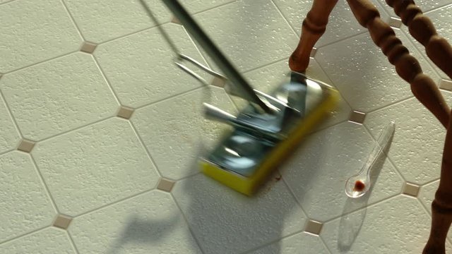 Cleaning floor, mopping spillage near high chair