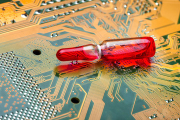 Glass transparent ampoule with red liquid modern medicine using electronic methods and cyber printed silicone circuit boards, close-up.