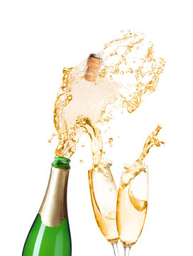 Champagne splashing out of bottle and glasses on white background