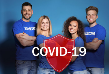 Volunteers uniting to help during COVID-19 outbreak. Group of people and shield illustration on...
