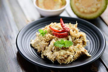 Northern Thai food (Tam Khanun), spicy pounded young jackfruit salad on black plate, Local Thai food