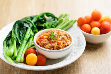 Northern Thai food (Nam Prik Ong), spicy chili minced pork with tomatoes in a bowl eating with vegetables, Thai chili paste