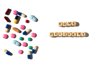 Flat lay of colorful pills and capsules with home delivery text. Pharmaceutical supply for customers concept