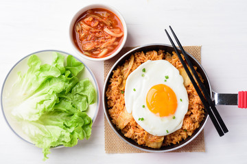 Kimchi fried rice with fried egg in small cooking pan on white table, Korean food, Top view