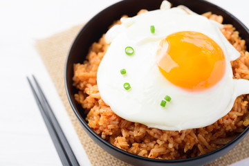 Kimchi fried rice with fried egg in bowl and chopsticks, Korean food