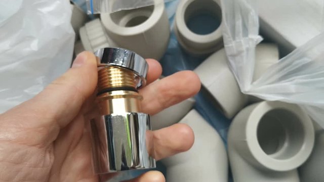 Plug for heated towel rail (dryer) in the palm of your hand. Brass chrome-plated threaded fitting. Real time, contains people, close-up