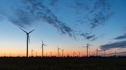 Windräder in Windpark nach Sonnenuntergang