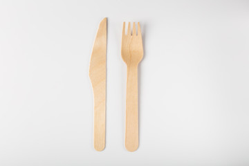 Wooden disposable environmentally friendly tableware top view on white background. eco hashtag