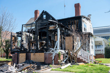 The burnt wood of the fire damaged house. The siding has melted.
