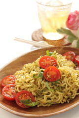 Asian food, cherry tomato and fried noodles on wooden plate
