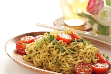 Asian food, cherry tomato and fried noodles on wooden plate
