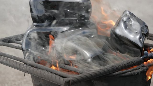 Roof repair. A bucket of boiling tar resin on bricks. Pieces of bitumen are melted in a bucket using a burner and fire