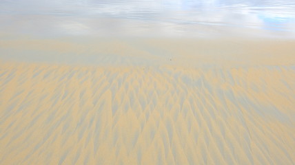 yellow blue sand and water texture as abstract background. Sand triangle patterns.Summer holiday while traveling around Australia.