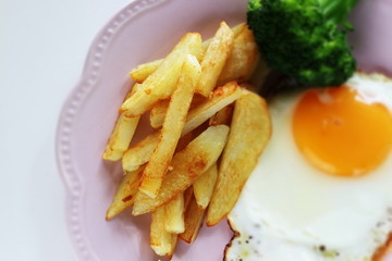 homemade French fries and sunny side up fried egg with broccoli 