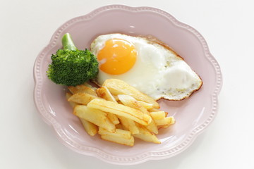 homemade French fries and sunny side up fried egg with broccoli 