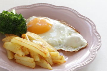 homemade French fries and sunny side up fried egg with broccoli 