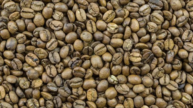 Great texture scene of coffee beans with the camera moving away from the beans in slow motion.