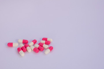 Obraz na płótnie Canvas White and pink medicine capsules and white background