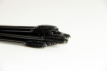 makeup artist set, lots of black mascara brushes on a white background close-up