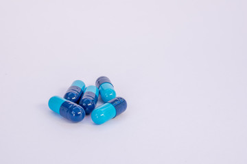 Bicolor blue medicine capsules on white background