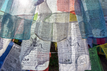 Colorful Buddhist Bhutanese Tibetan prayer flag (lungta) with 'Om Mani Padme Hum' mantra (mean compassion, ethics, patience, diligence, renunciation and wisdom in English) in Bhutan.(Selective Focus)