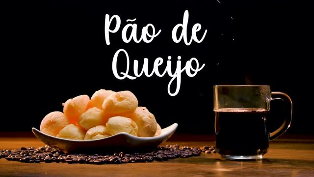 A typical Brazilian food, P&atilde;o de queijo. Next to it appears written in Portuguese P&atilde;o de queijo