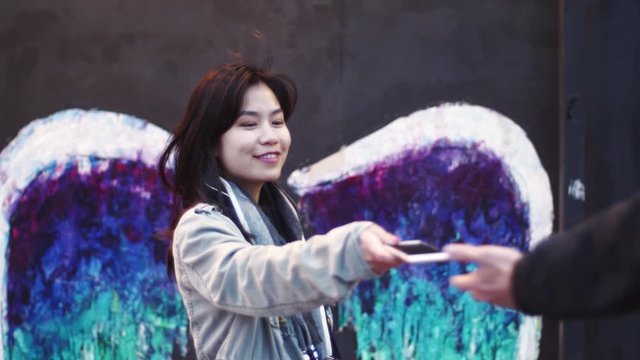 Asian girl woman asks for picture graffiti mural art wall angel wings