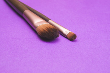 Makeup brushes on purple background. various cosmetic brushes. skin care accessories