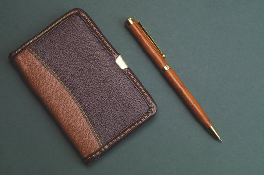 Blank paper of notepad with wooden pen. office supplies. diary with leather cover
